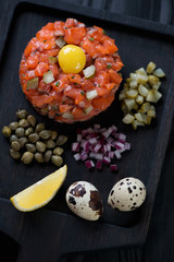 Salmon tartar with quail egg yolk, capers, red onion and pickles