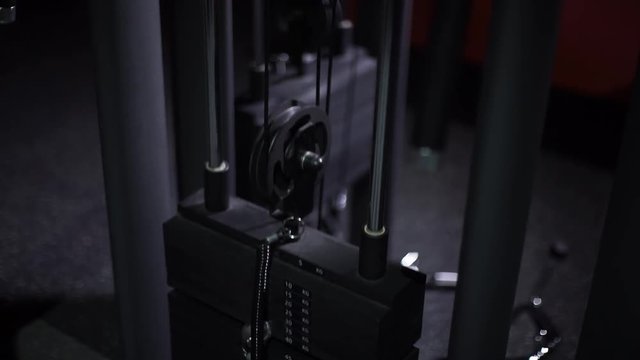The weight stack from a cable exercise machine 4k close-up video. Gym and workout equipment for training. Working mechanism of rack machine: plates weighs twenty kg moves, lifts, rises and pulls up