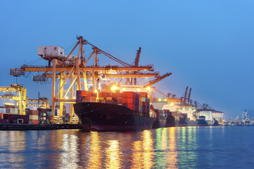 Containers loading by big crane at dark sunset, Shipping Trade Port in Thailand