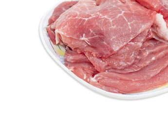 Sliced uncooked pork on dish closeup