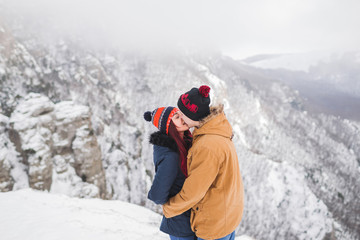 Fototapeta na wymiar Couple in love walking in winter mountains. Beautiful view with