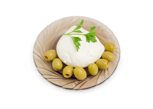 Mozzarella cheese with parsley and green olives on glass saucer