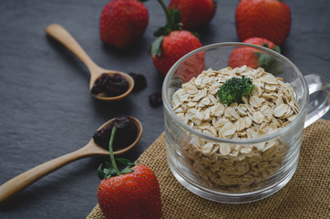 Fresh breakfast of healthy oatmeal in glass with strawberries on