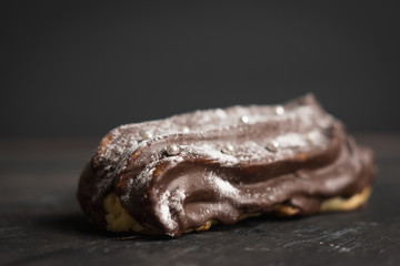 Chocolate eclair on the dark background. Shallow depth of field.