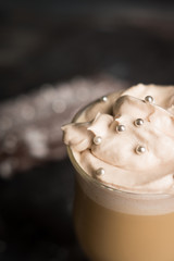 Coffee and chocolate eclair on dark wooden background. Shallow depth of field.