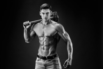 Fototapeta na wymiar Muscular man with naked torso holding big hummer. Isolated on dark grey background