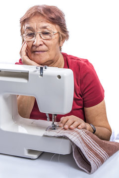 Elderly Woman Sews On The Sewing Machine 