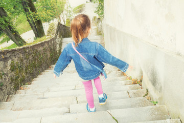 Kid girl going down the stairs alone.