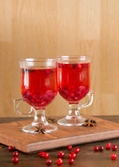 Aromatic cranberry tea with spices in glass, close up