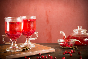 Aromatic cranberry tea with spices in glass, close up