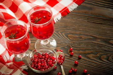 Aromatic cranberry tea with spices in glass, close up