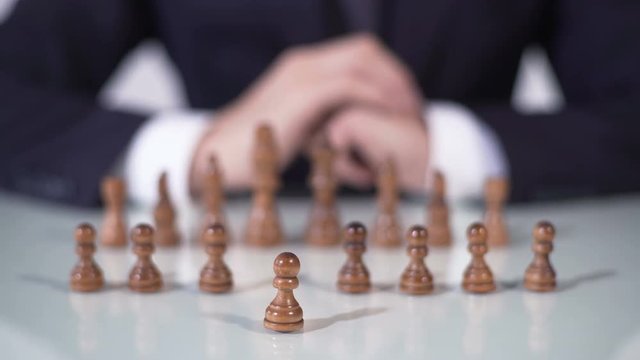 Player sacrificing pawn in chess game, startup company entering large market