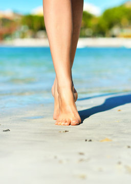 Close-up view of women's legs on the beach.