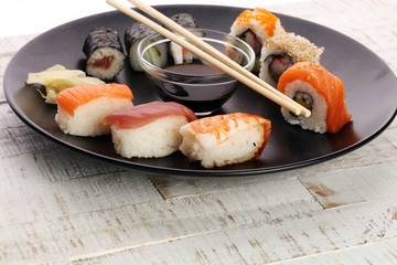 close up of sashimi sushi set with chopsticks and soy - sushi roll with salmon and sushi roll with...