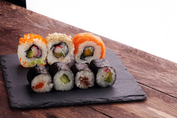 close up of sashimi sushi set with chopsticks and soy - sushi roll with salmon and sushi roll with...