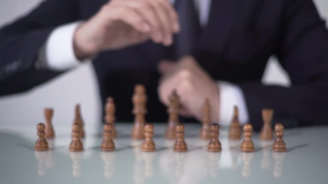 Man moving pawn in chess game, involving voters in unfair political strategy