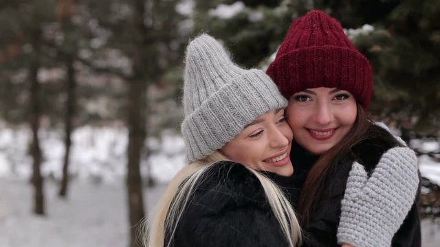 Portrait of two pretty girls in hats in the wintertime.