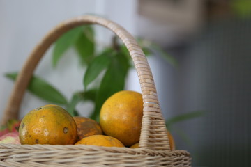 Fresh oranges group and nature green leaves in basket blur background