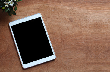 Empty tablet on wood work desk, soft focus vintage color tone, business and education background