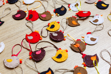 Fototapeta na wymiar Handmade felt owl toy, sheets, scissors, thread, pins, needle on a brown wooden background