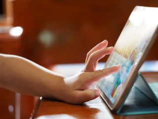 Kid using tablet with blurred focus for background