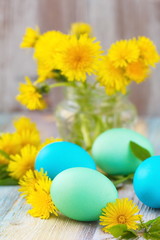 Easter eggs and flowers on wooden background