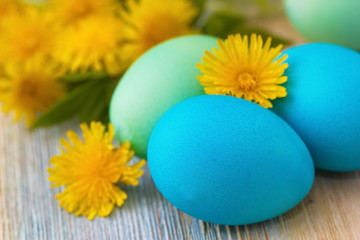 Easter eggs and flowers on wooden background