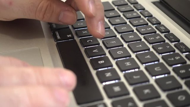Male hands typing copy and paste keys combintaio on a laptop keyboard. Side view
