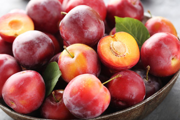 Fresh plums on a grey wooden table
