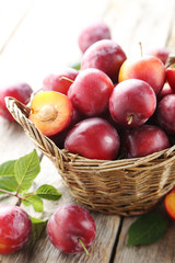 Fresh plums on a grey wooden table