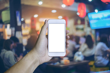 Man's hand shows mobile smartphone in Japanese izakaya style res