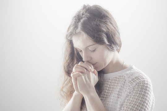 Praying Woman On White Background With Shine.