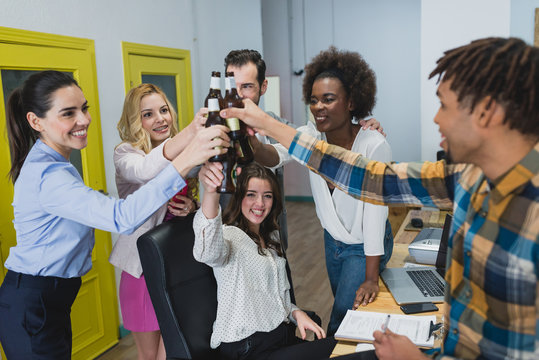 Cheerful office people clanging bottles