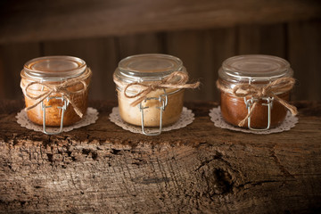Jars of almond, cashew, and peanut butters sitting in sequence