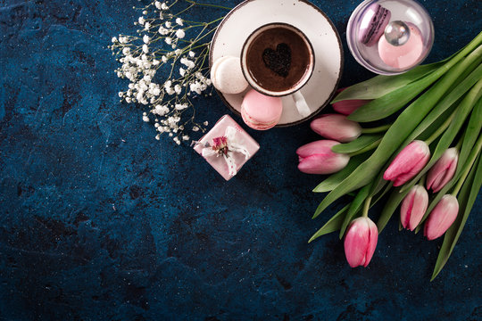 romantic breakfast Cappuccino ,strawberry macaroons, pink tulips, gift box on blue table.Valentine's day concept