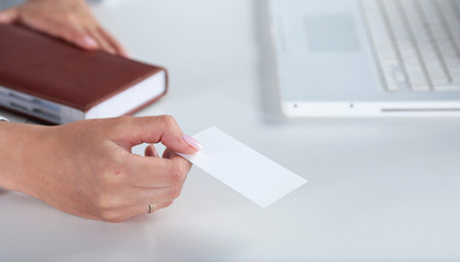 Businesswoman holding blank visit card ,sitting on the desk