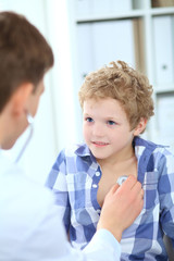 Male doctor auscultating a little boy by stethoscope. Health care, insurance and help concept.