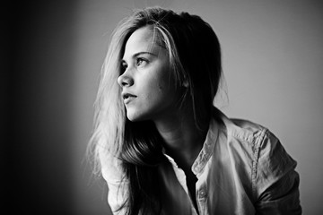 studio portrait of a blond woman on black background