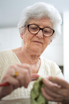 Senior woman knitting. Focus on woman's head.