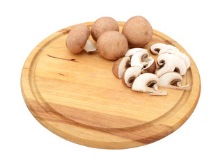 Sliced and whole chestnut mushrooms on a wooden cutting board
