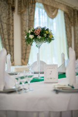 The table decorations for weddings with tall flower arrangement. Wedding concept