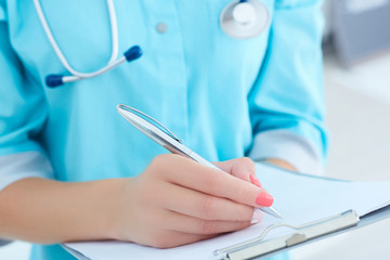 Female medicine doctor hand holding silver pen writing something on clipboard closeup. - obrazy, fototapety, plakaty