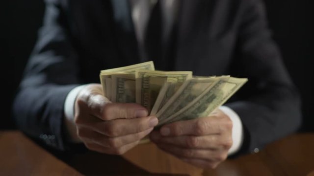 Corrupt official counting bundle of money, taking bribe for abuse of power