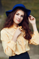 young woman posing in the street in hat