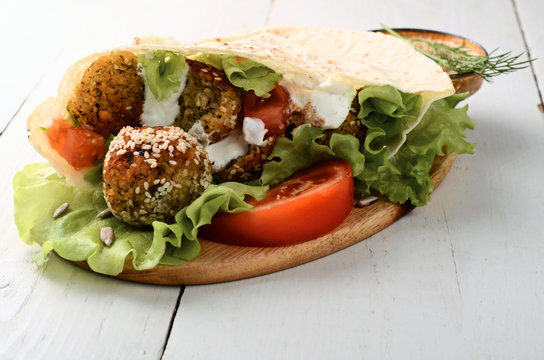 falafel in pita bread on white wooden table