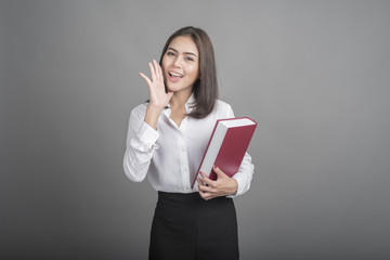 Beautiful teacher Woman holding book on grey background