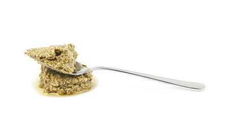 Spoon of green pesto isolated