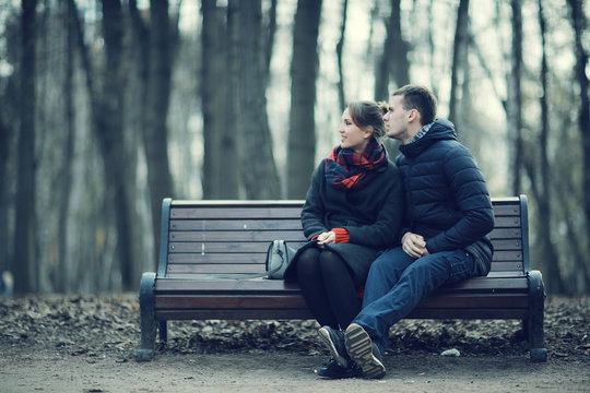 Couple Cuddling On A Bench In Winter