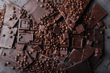 Coffee beans with chocolate  dark chocolate. Broken slices of chocolate. Chocolate bar pieces. A large bar of chocolate on gray abstract background. Coffee beans. Sweet food photo concept. Copyspace