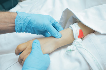 Doctor feeling patient`s pulse in ICU